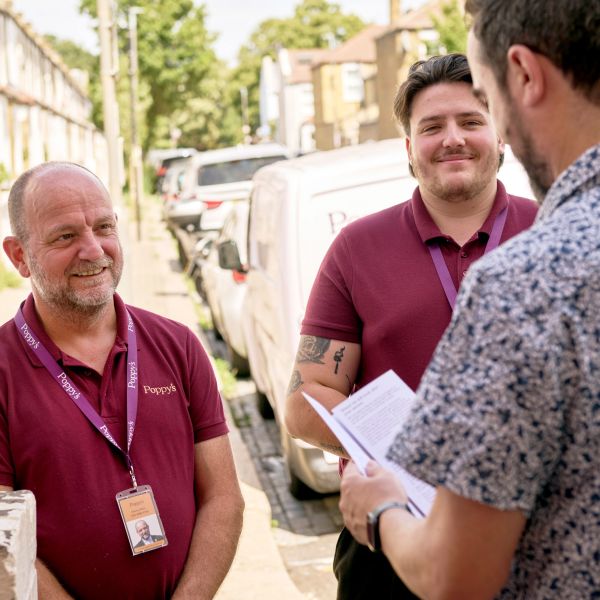 Danny Liam smiling handing leaflet at the door of a home collection