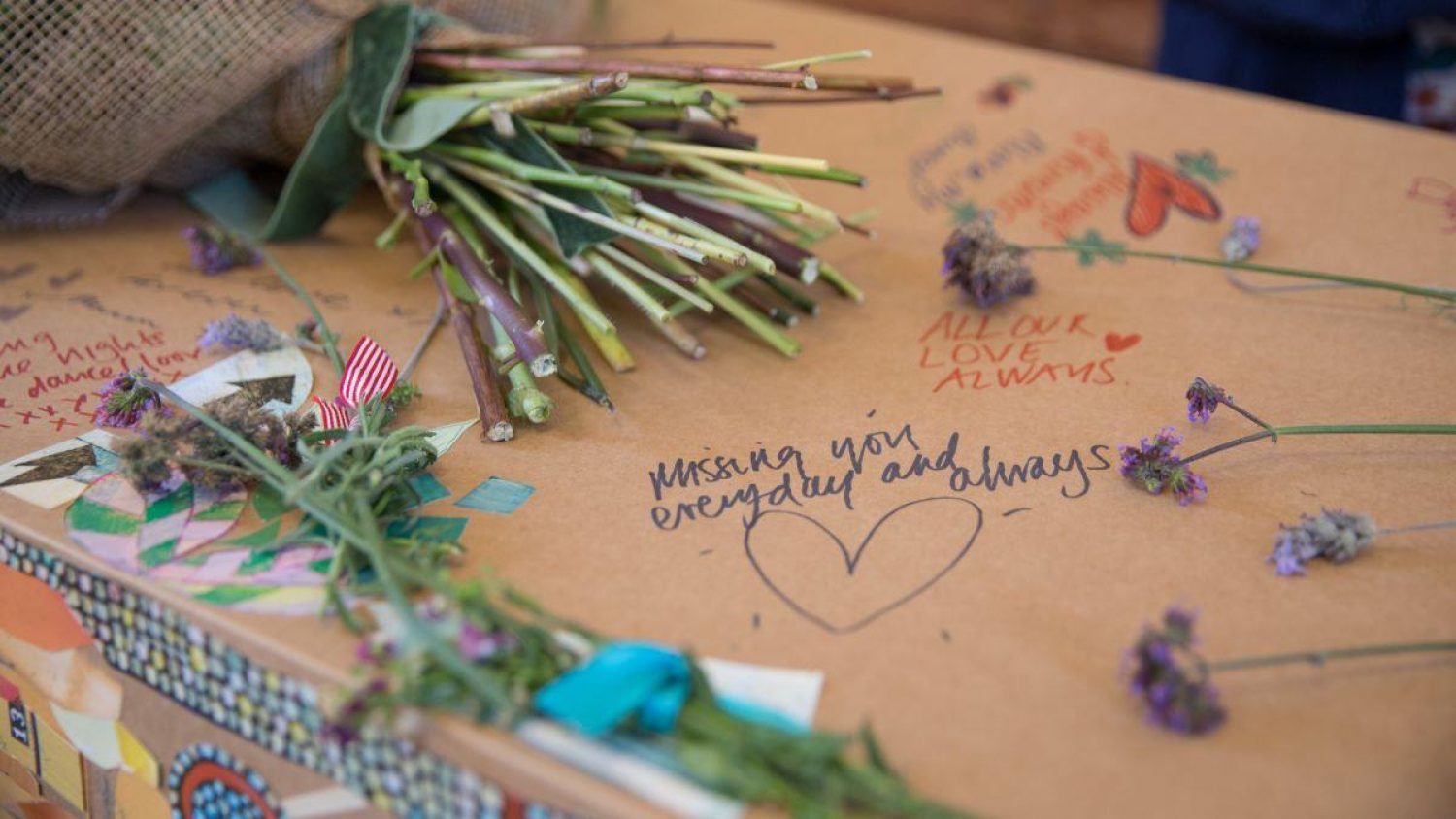 Close up of coffin with messages and flowers. Image credit: Good Funeral Guide