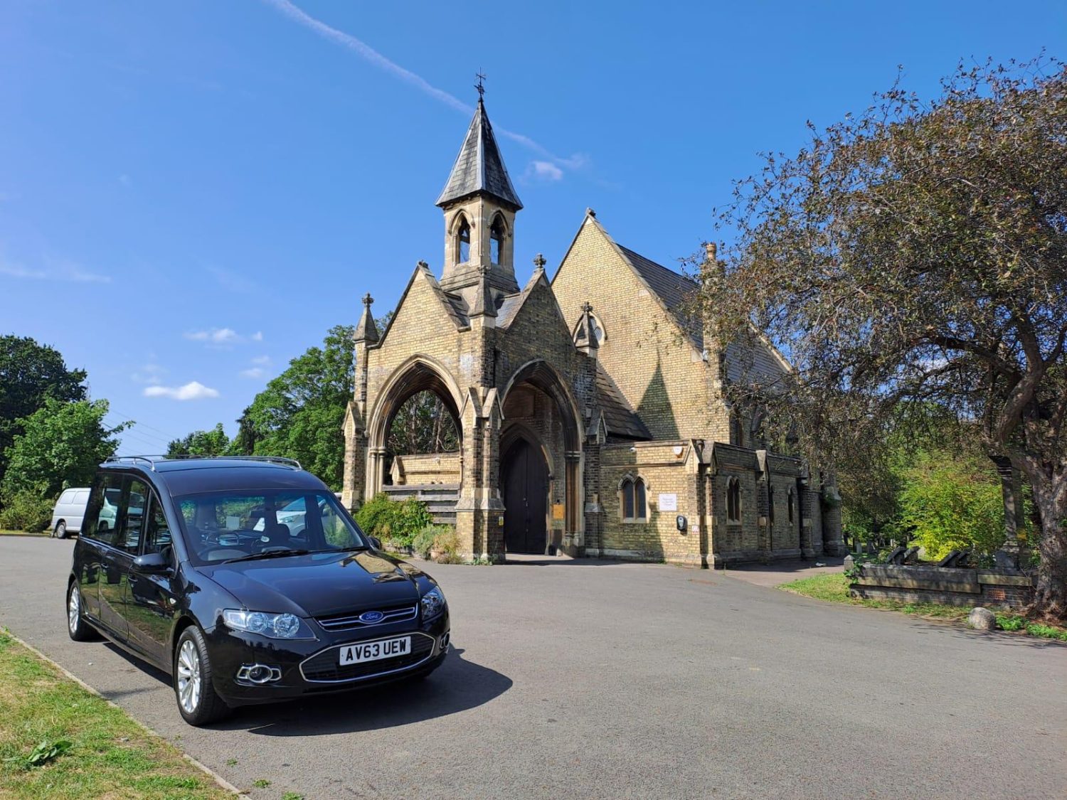 Poppy's old chapel mortuary with black hearse outside and trees
