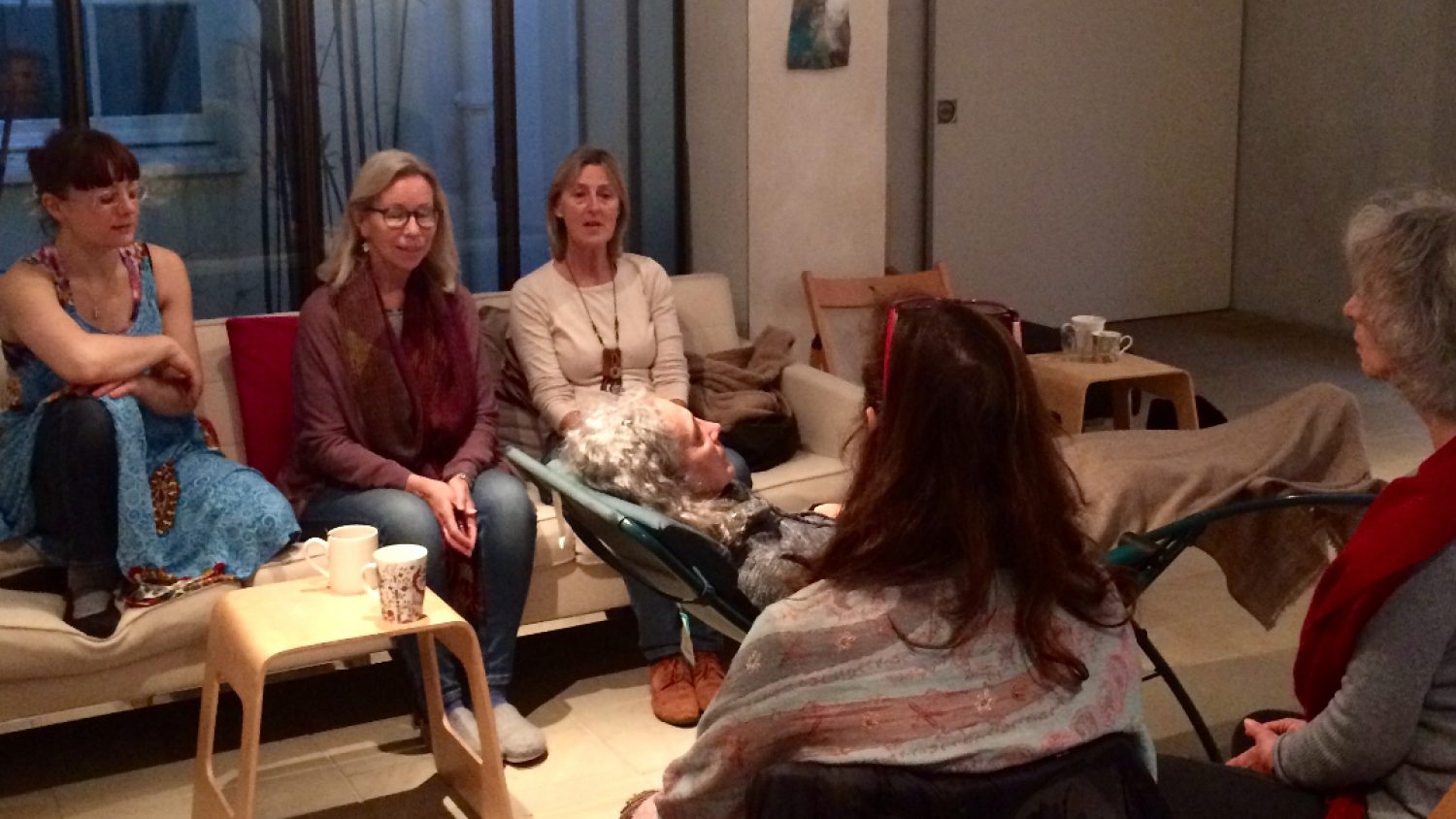 Heart of London Threshold singers - group of women in a circle around a woman lying down, singing