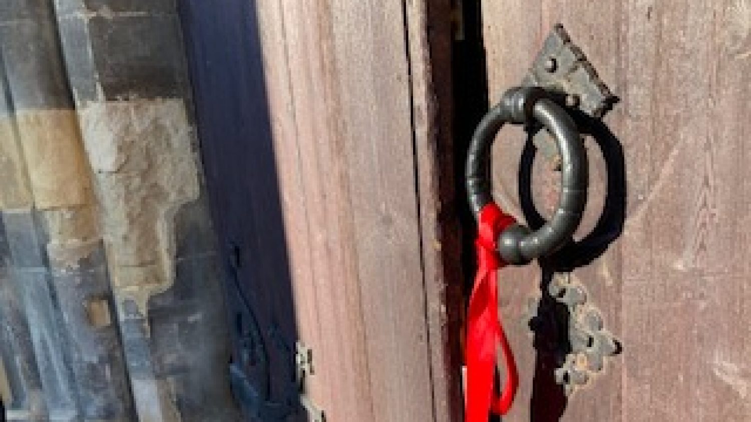 Red ribbon on door of Poppy's mortuary to show that a visit is taking place