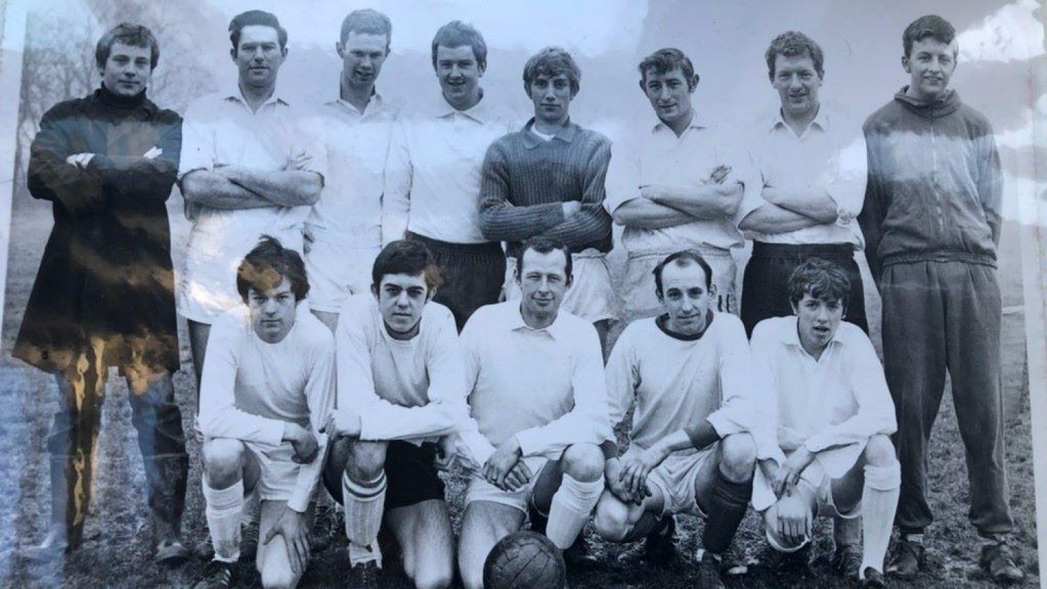 Black and white photo of men in football team kit
