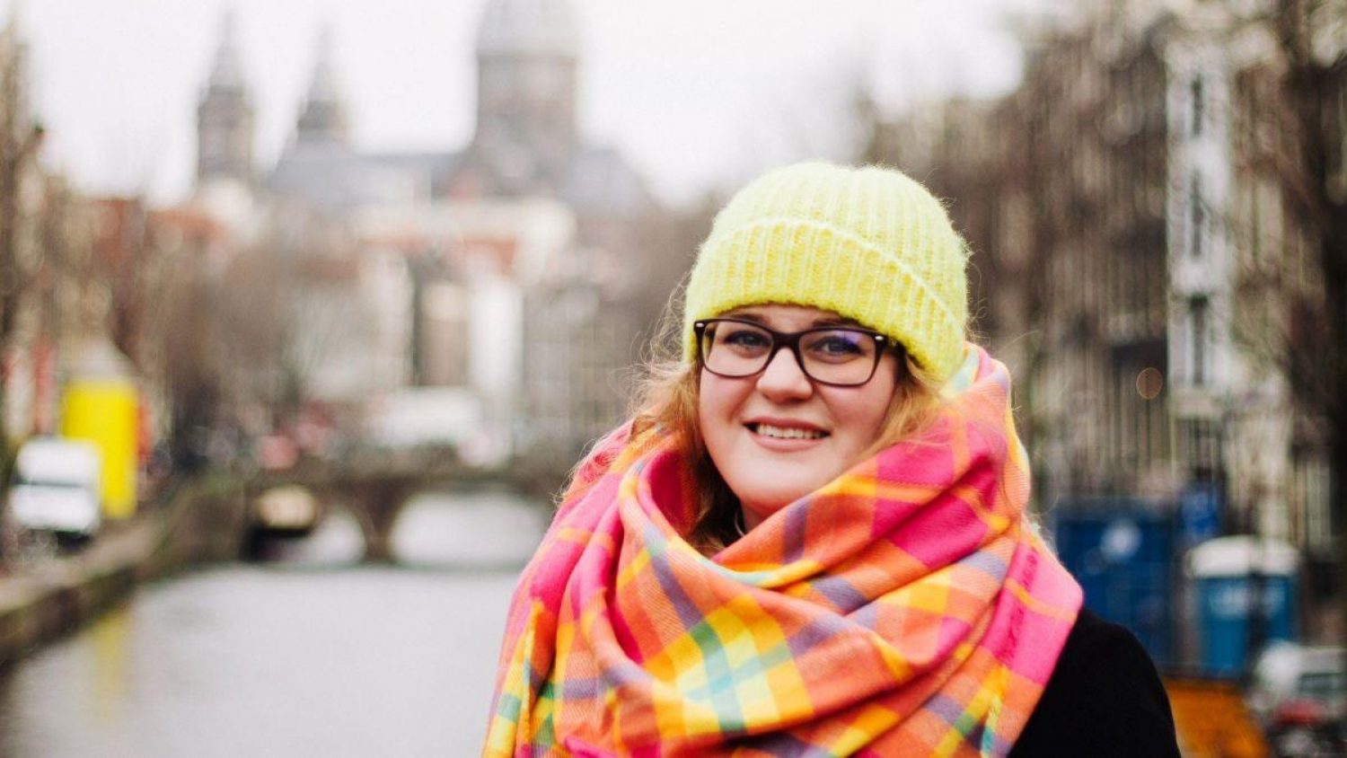 Katharine Horgan, founder of Young Orphans, in yellow hat with street view behind her.