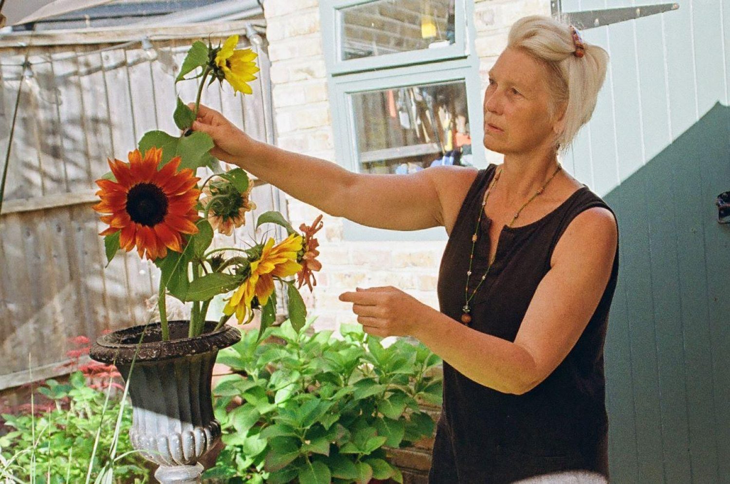 Lilian Highmoor, florist in her garden with yellow and orange flowers