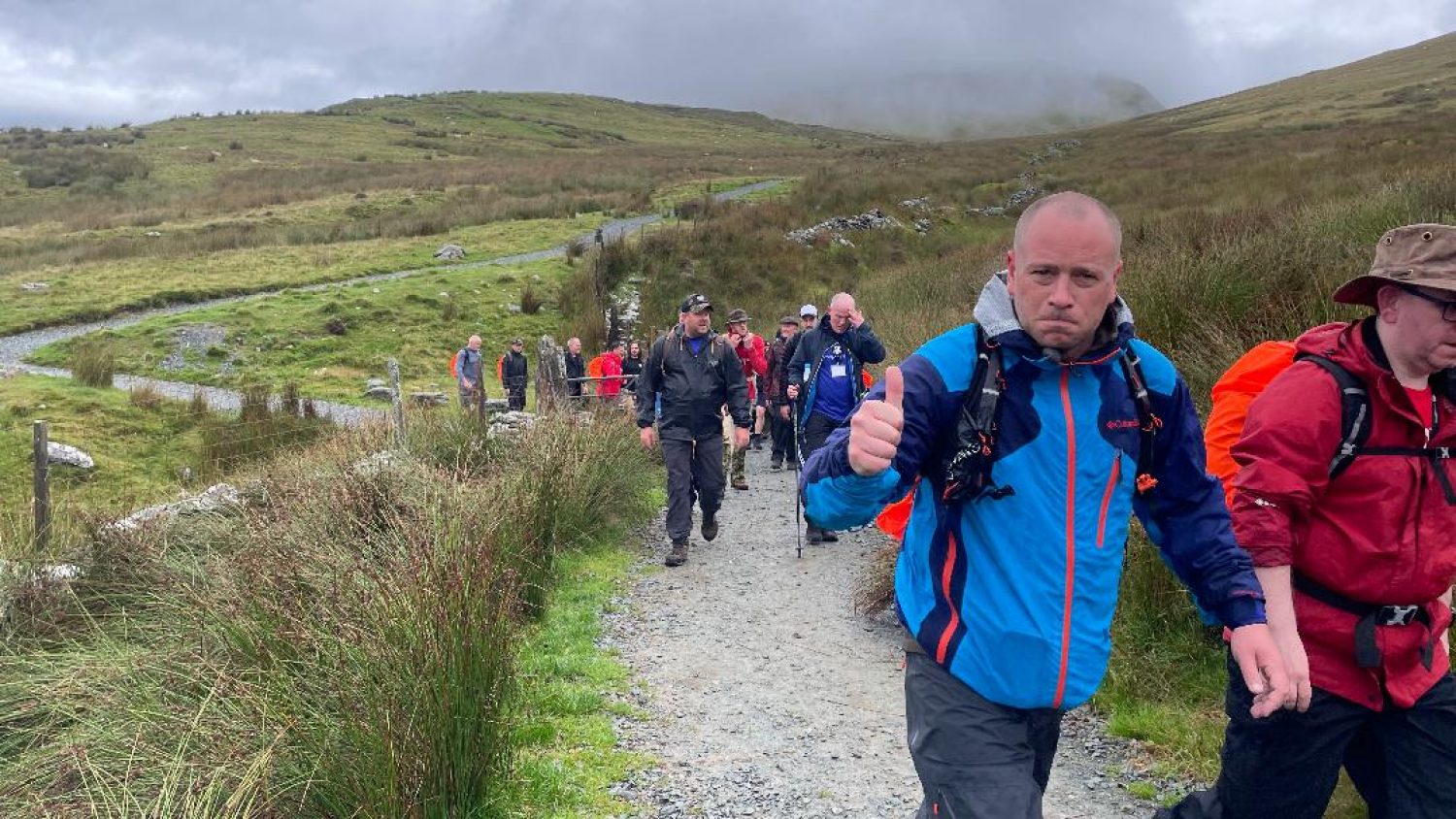 Mark Childs on a StrongMen weekend with group of men walking on a path up Snowdon