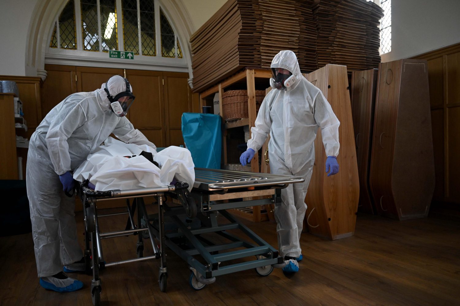 Two people in protective clothing working in Poppy's mortuary during Covid 19