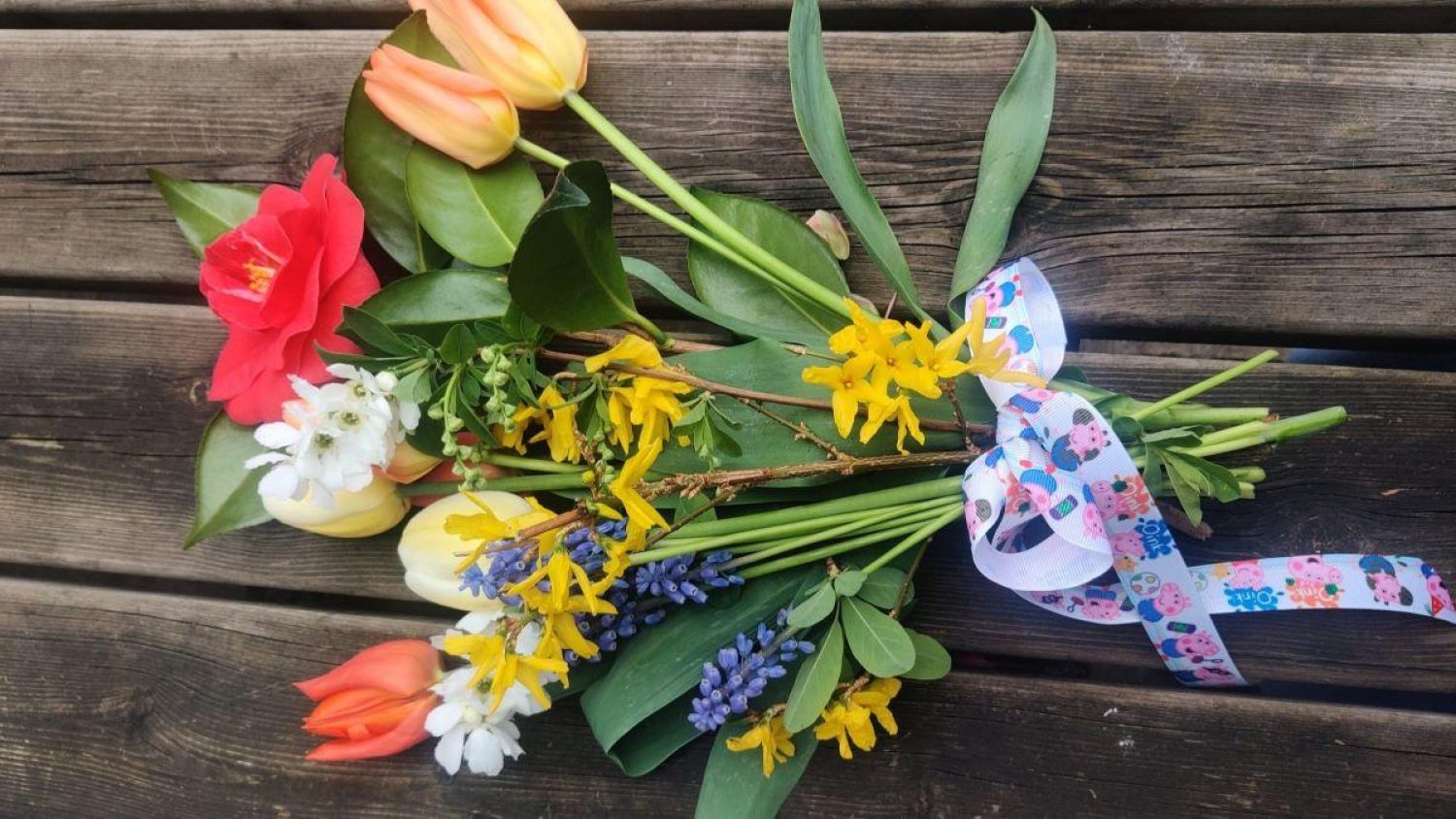 Brightly coloured flowers tied with a Peppa Pig ribbon