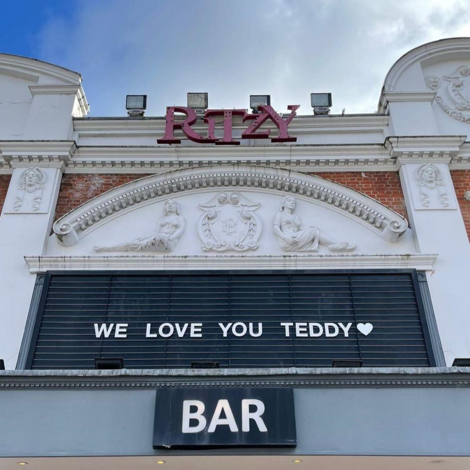 'We love you Teddy' in white letters on black hoarding outside Ritzy cinema in Brixton