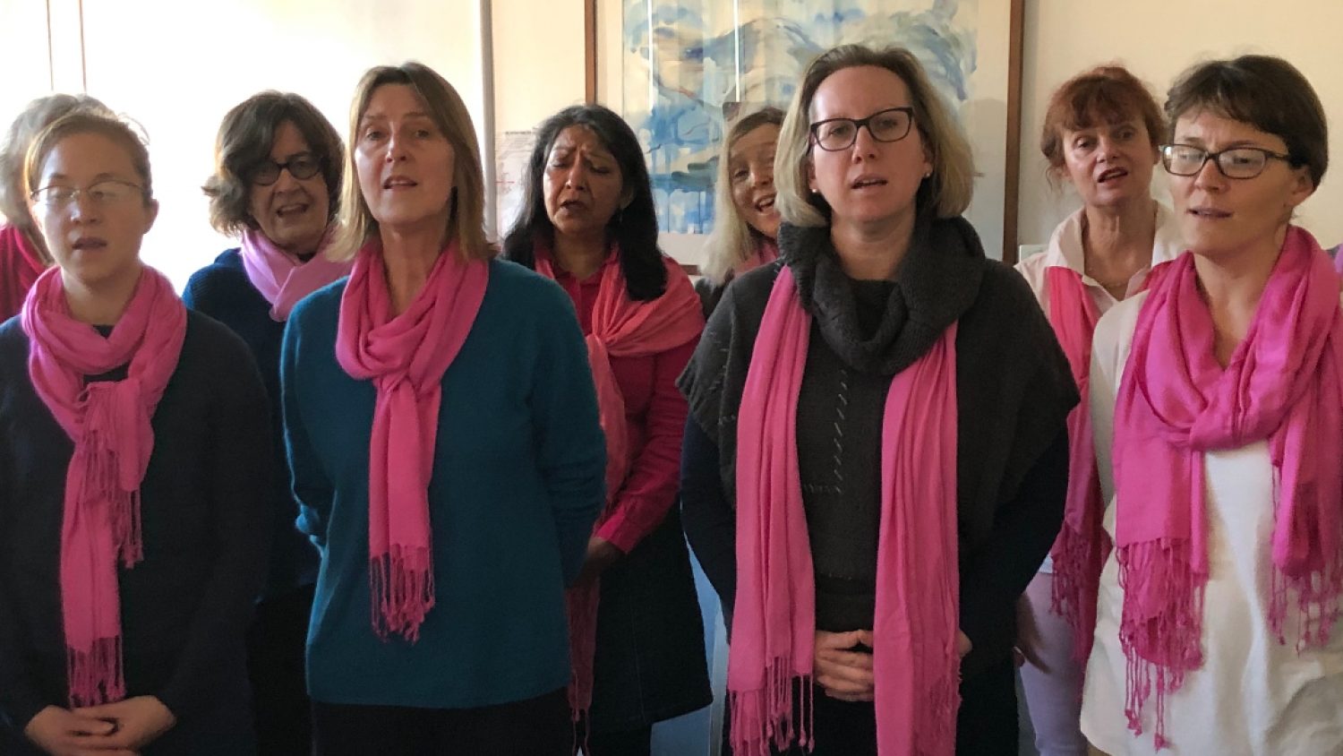 Heart of London Threshold singers - group of women with pink scarves singing