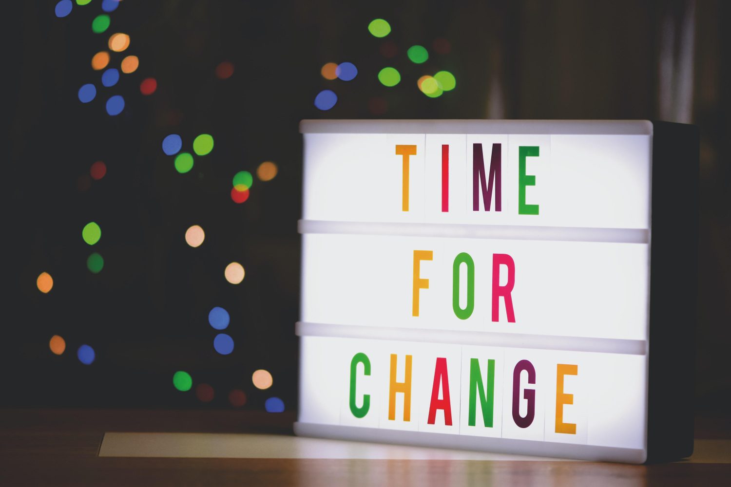 'Time for Change' written on a lightbox with multi-coloured letters