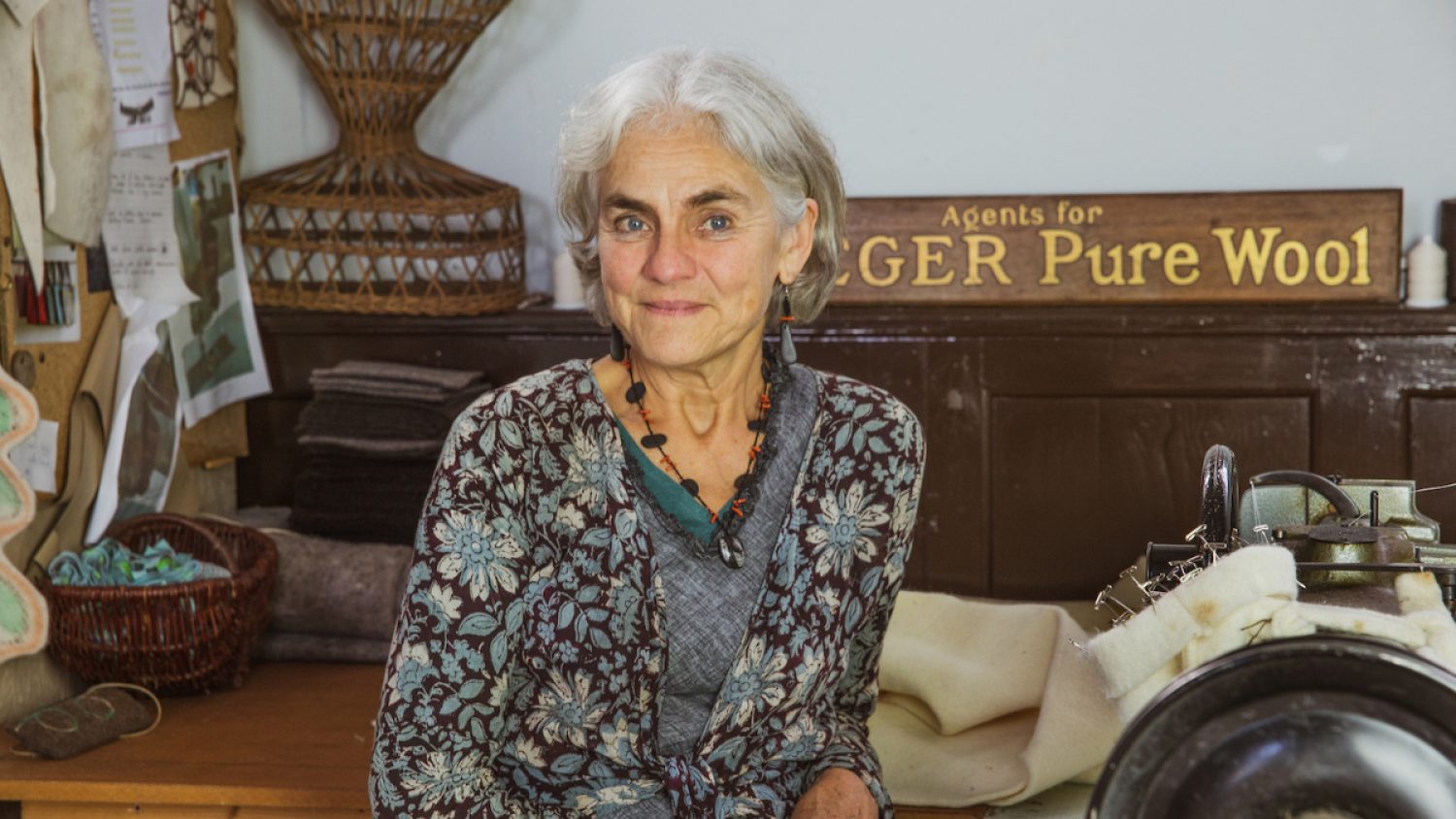 Yuli Somme from Bellacouche by Fern Leigh Albert, in studio with felting materials and sign saying 'Pure Wool'