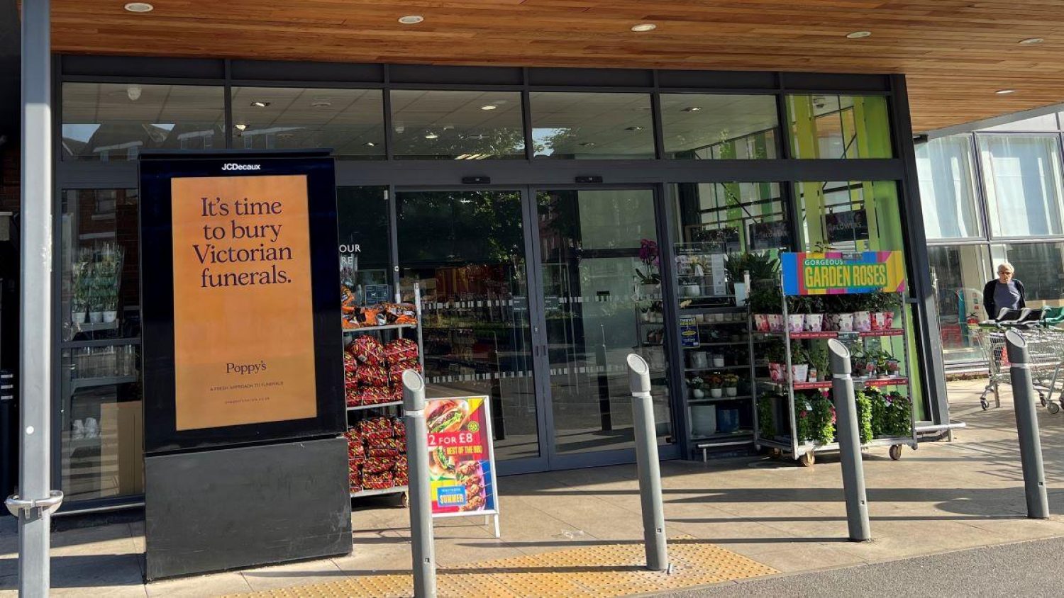 Poppy's ad billboard in sunshine reading: It's time to bury Victorian funerals on orange background
