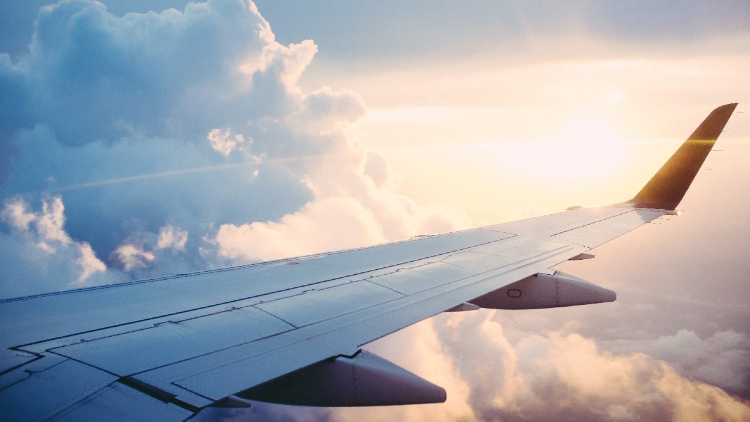 Aeroplane wing with clouds and sun behind, Ross Parmly, Unsplash, Poppy's funerals
