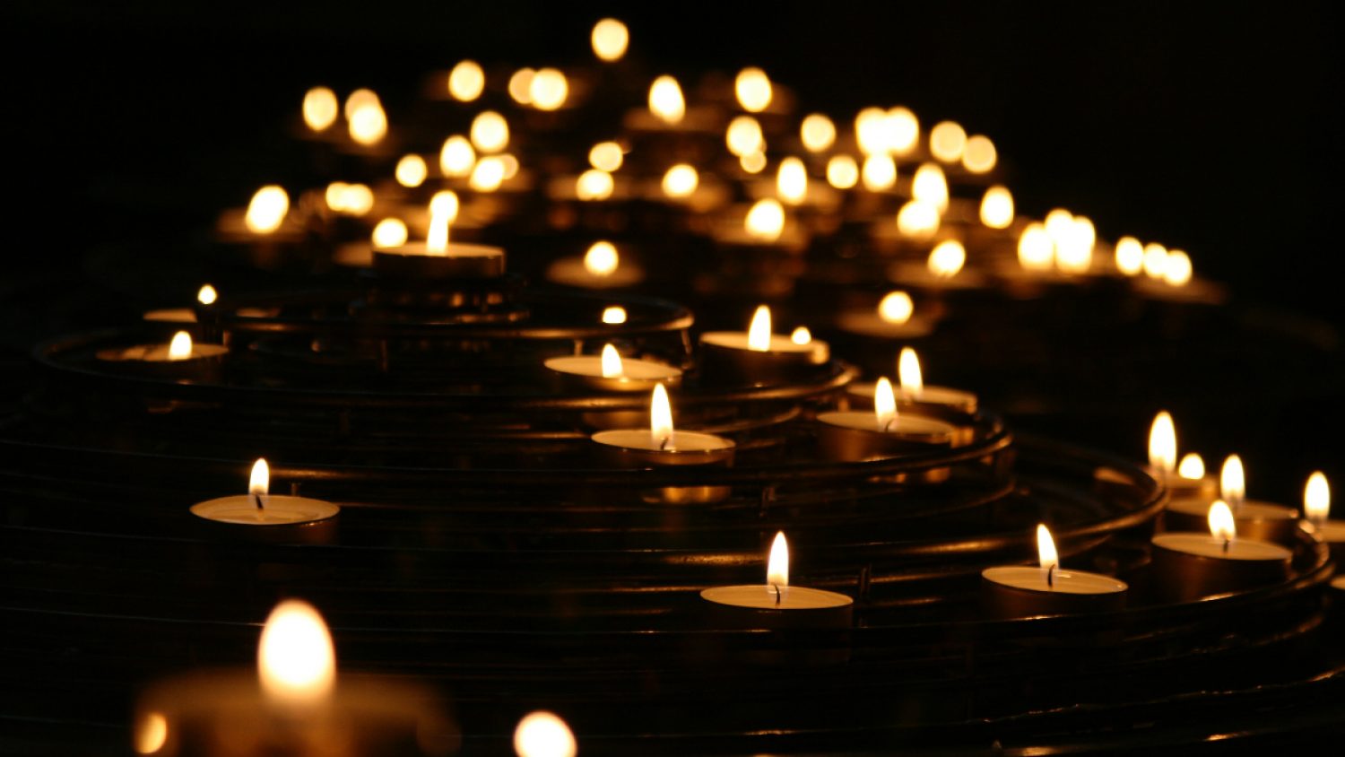 Lots of small candles on a dark background