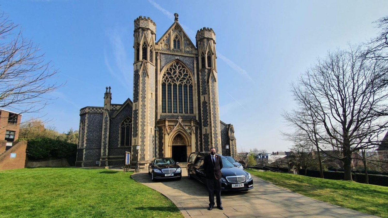 Church building with hearse and Poppy's team member outside on a sunny day