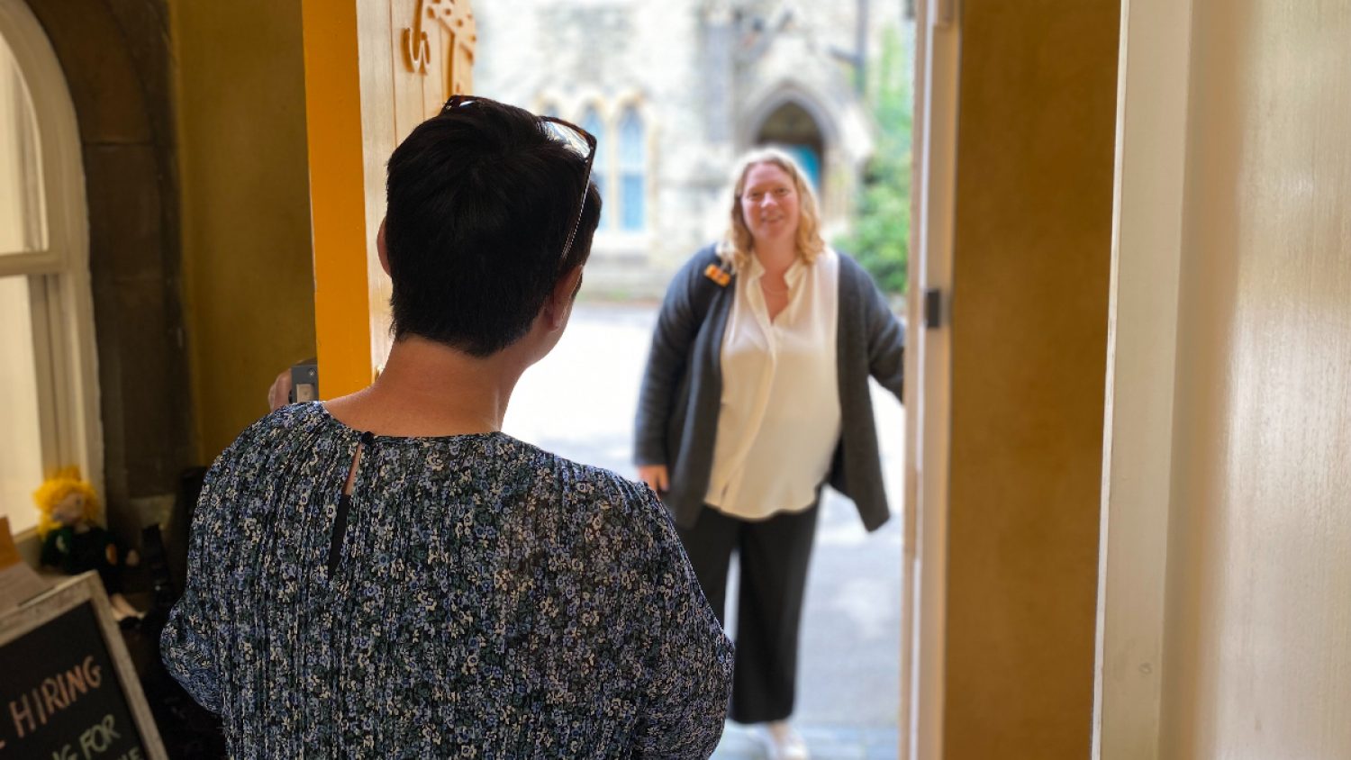 Woman opening door at Poppy's to meet new client, London funeral directors