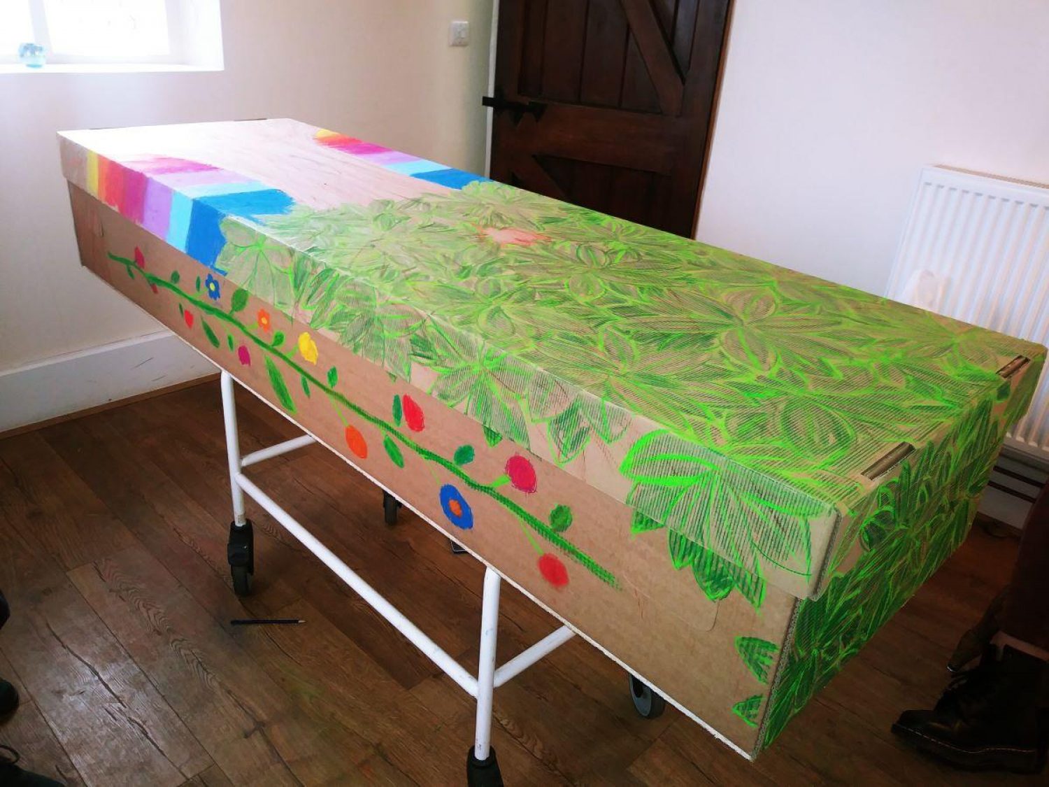 cardboard coffin decorated with flowers and leaves | Poppy's funerals | London funeral directors