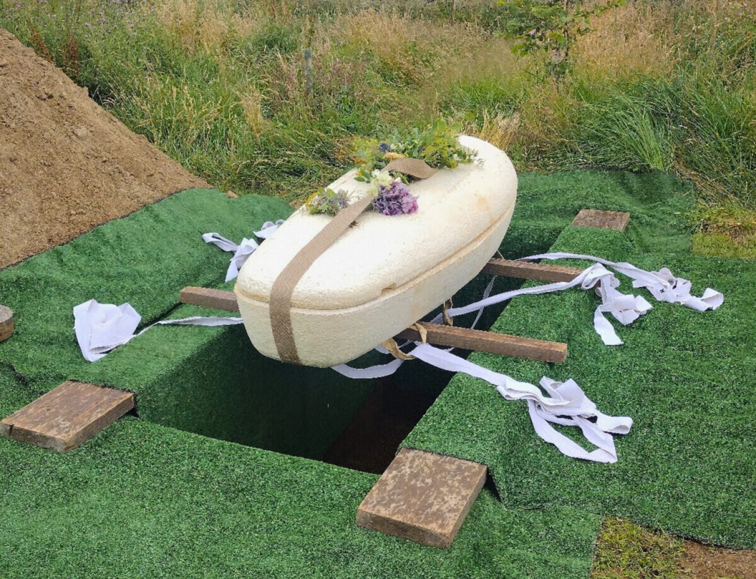 A mushroom coffin resting on putlogs over a grave at a natural burial site