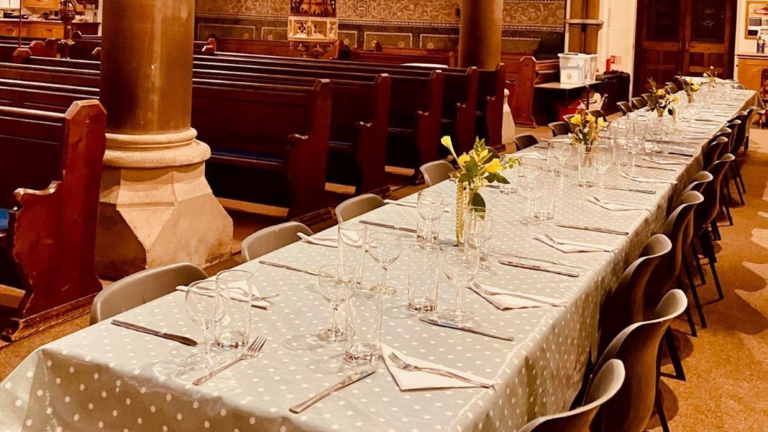 Table laid for lunch with tablecloths and flowers at Christ Church, East Sheen, at funeral planning day