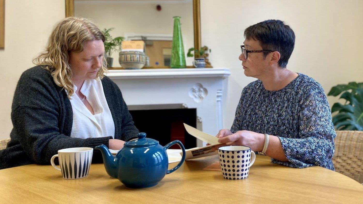 Poppy's team discussing funeral wishes at Poppy's offices over a cup of tea