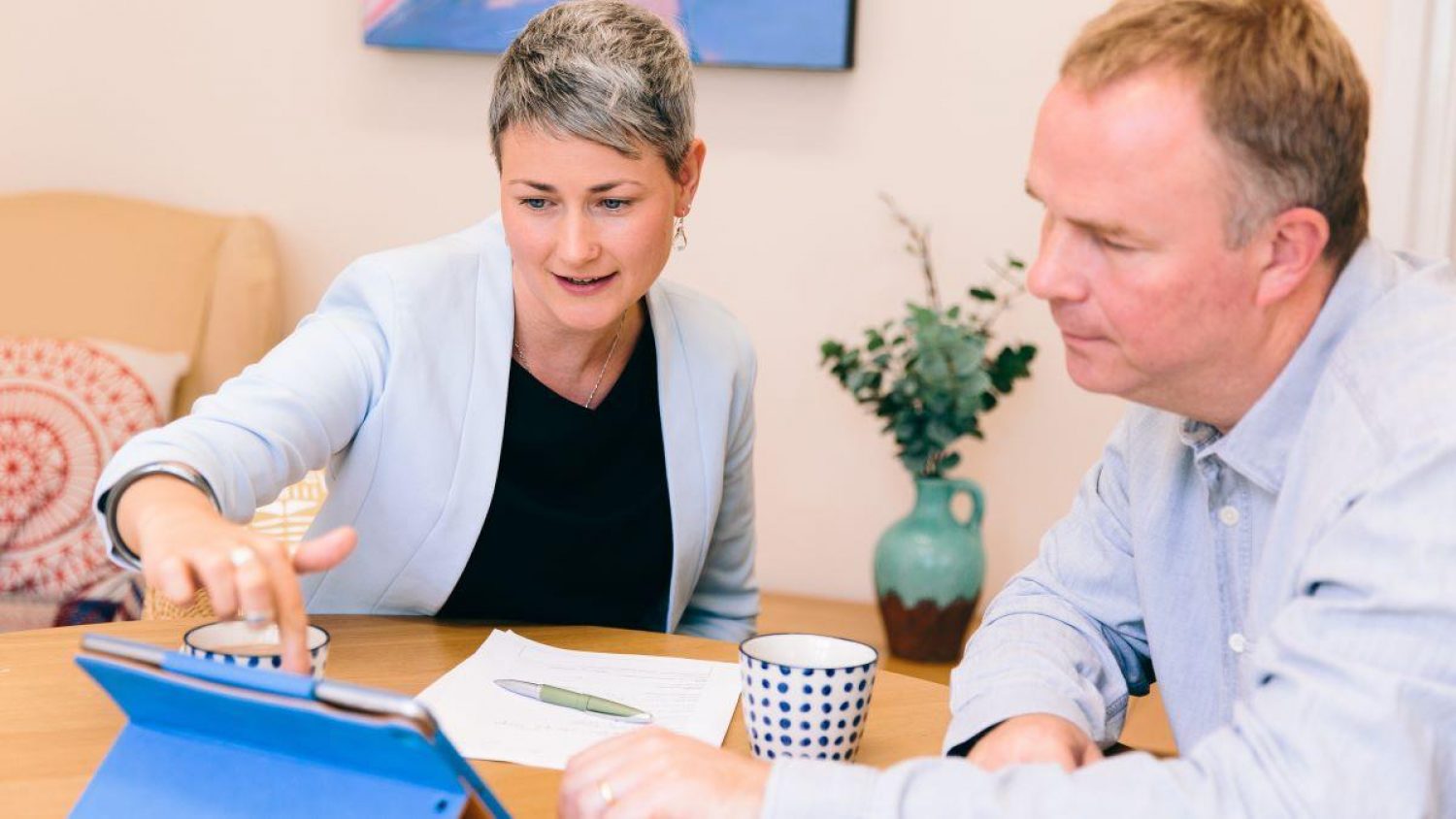 Two people looking at an i pad and choosing options at Poppy's, London funeral directors