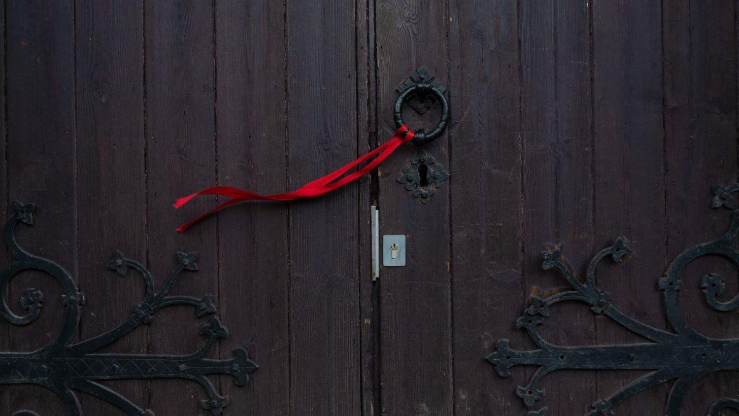 A red ribbon on a wooden door.