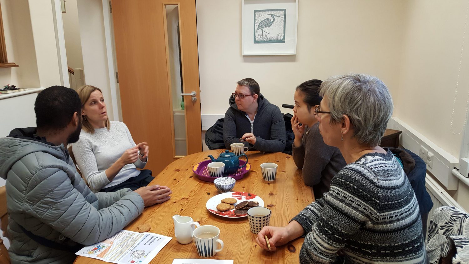 A group of people talking around a table at Poppy's funerals Tooting HQ