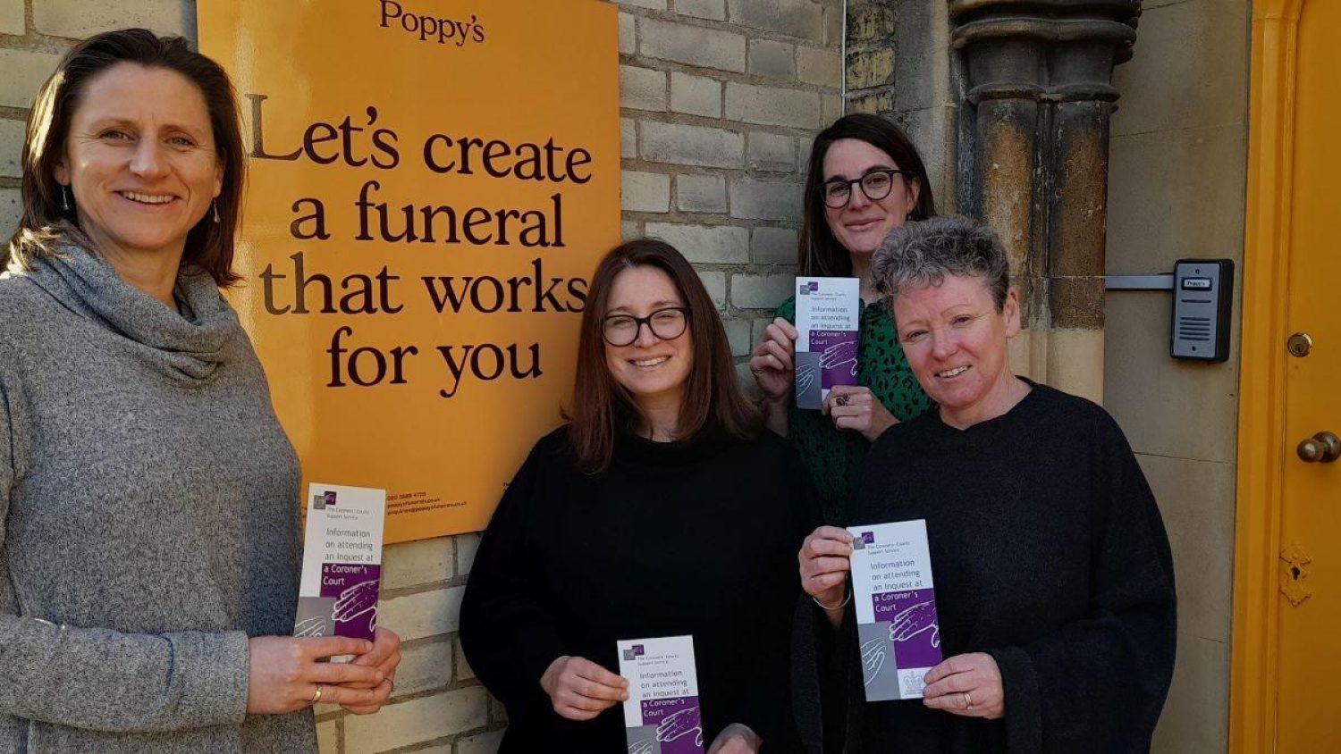 Four women outside Poppy's HQ with Coroner's Court Support Service leaflets. Sign says: Let's create a funeral that works for you