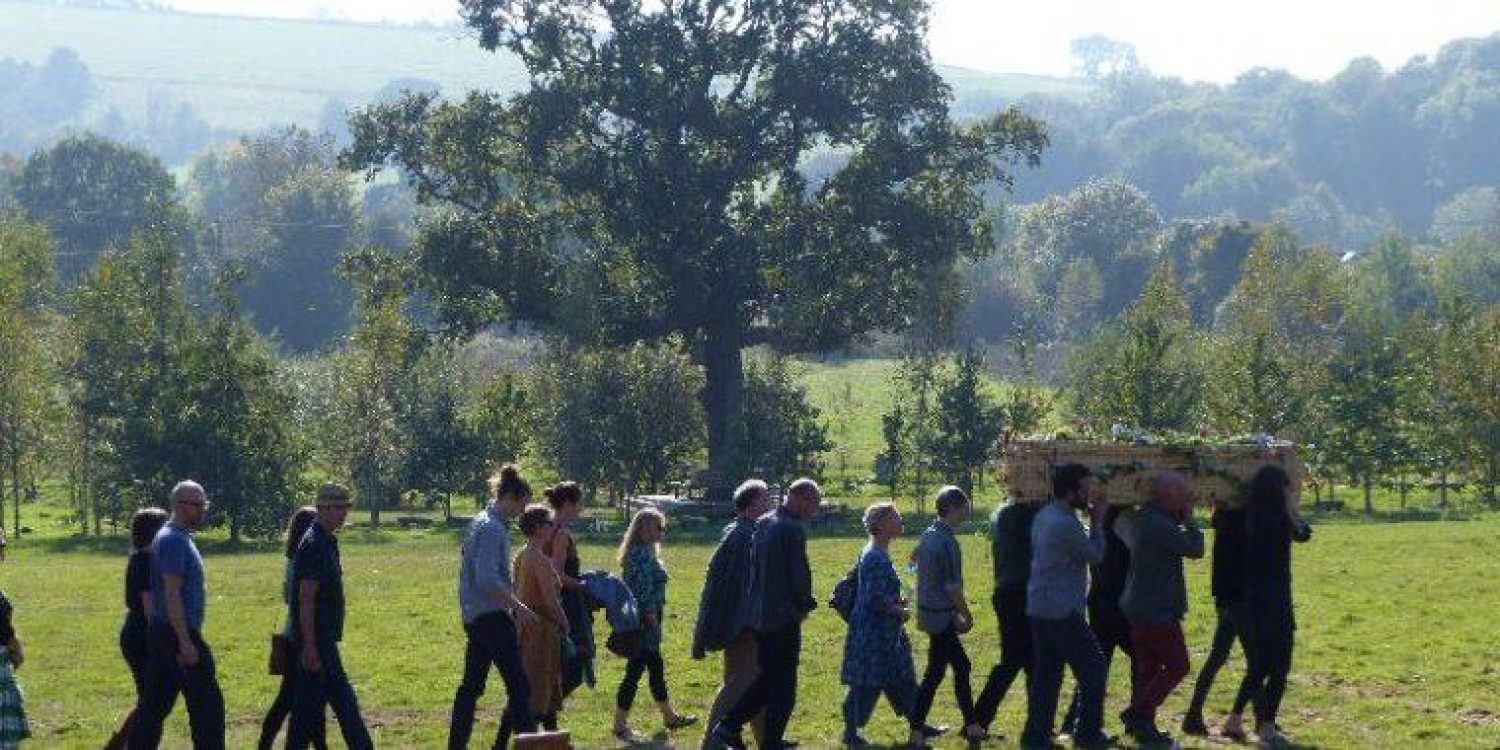 Group of people carrying coffin in countryside | Poppy's funerals | best funeral directors
