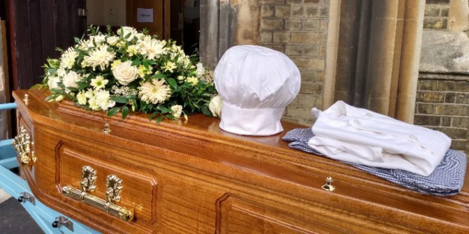 Coffin with flowers and chef's whites